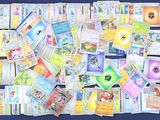 une grande collection de cartes Pokémon posées sur une surface bleue