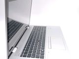 a silver laptop with a black keyboard on a white surface