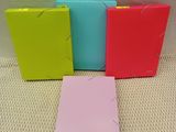 quatre classeurs de couleurs différentes posés sur une surface blanche