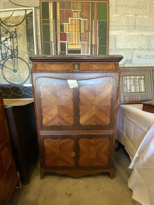 une armoire en bois surmontée d'un miroir, dans une pièce