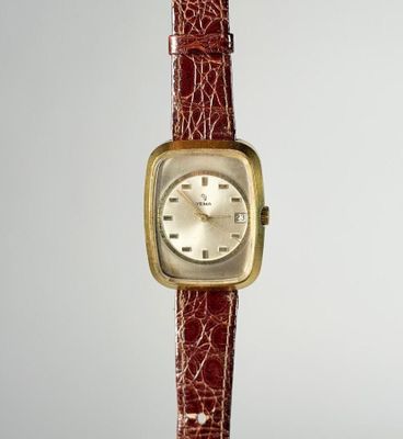 une image d'un gros plan d'une montre-bracelet sur une surface blanche