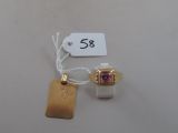 a small gold ring with a pink stone on it
