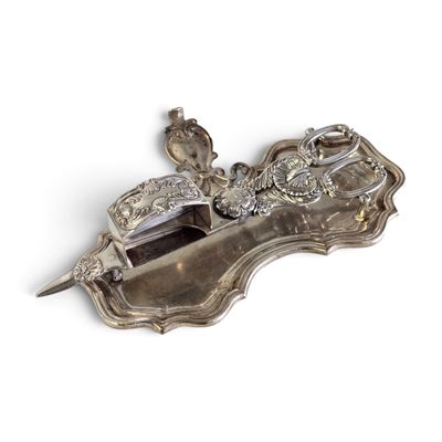 une assiette en argent ornée d'un oiseau sur un fond blanc