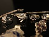many different rings and bracelets sitting on a table