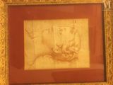 a picture of a drawing in a gold frame on the wall