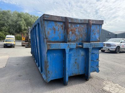une benne bleue posée au milieu d'un parking