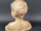 a close up of a sculpture of a child ' s head on a black surface