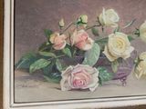a painting of roses in a gold frame on a table