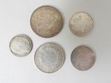 six different british coins sitting on top of a white surface