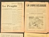 several old french newspapers sitting on top of a black table