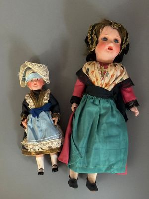 deux poupées, représentant une femme et un enfant, sont assises l'une à côté de l'autre