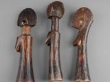 three wooden figurines of a woman and a man on a gray background