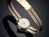 a close up of a watch on a black surface with a black background