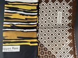two pieces of african print fabric, one brown and one white