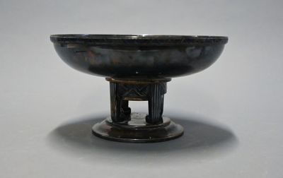 a black bowl on a stand on a white surface