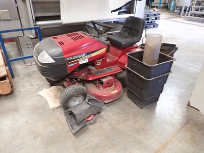 une tondeuse à gazon rouge posée par terre dans un garage