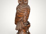 an owl statue sitting on top of a tree stump