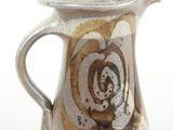 a brown and white pitcher on a white surface