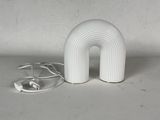 une lampe blanche posée sur une table blanche