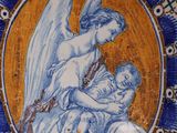 a blue and yellow plate with a picture of an angel holding a child
