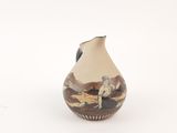 a small vase with a painting on it on a white surface