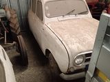 two old cars parked in a garage next to each other