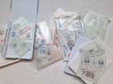 Plusieurs enveloppes et timbres sont posés sur une table blanche.