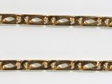 a close up of two gold chains on a white surface