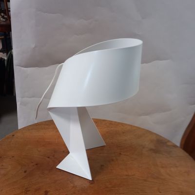 a white table lamp that is on a wooden table