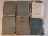 six vieux livres empilés les uns sur les autres sur une table
