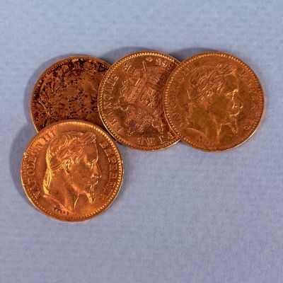 quatre types différents de pièces d'or sur un fond bleu