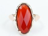 a close up of a ring with a red stone in it