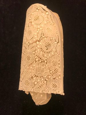 a close up of a piece of white lace on a black surface
