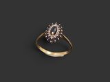 a gold ring with an oval sapphire stone surrounded by small white diamonds