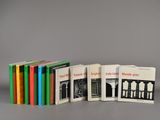 six livres alignés sur une table, sur fond gris