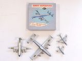 five model airplanes on the wall next to a book