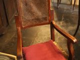 une chaise en bois avec un coussin rouge dans une pièce