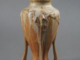 un vase marron orné d'un éléphant sur un fond gris