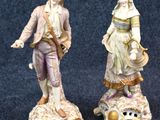 deux figurines représentant un homme et une femme debout sur un coquillage