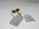 une paire de boucles d'oreilles plaquées or posées sur un fond blanc, avec une étiquette de prix