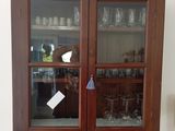 une armoire avec une porte vitrée et une étagère sur laquelle sont posés des verres à vin