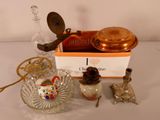 a box with a candle, a candle holder, a glass bowl, and a candle on a table
