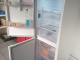 a white refrigerator with its door open in a kitchen