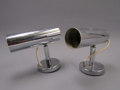 two silver lamps that are on top of each other