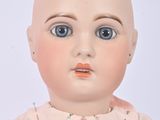 a baby doll with a bald head and blue eyes