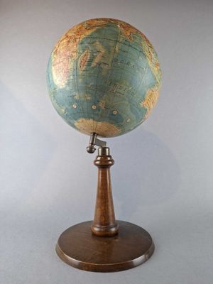 an old globe on a wooden stand with a white background