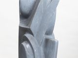 a gray sculpture on a white pedestal on a white surface
