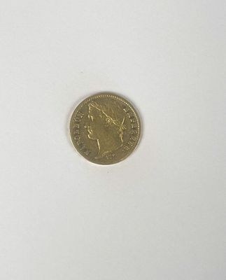 a gold coin on a white surface with a white background
