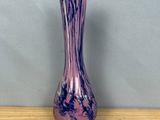 a purple vase sitting on top of a wooden table