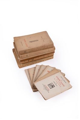 une pile de livres empilés les uns sur les autres sur une surface blanche